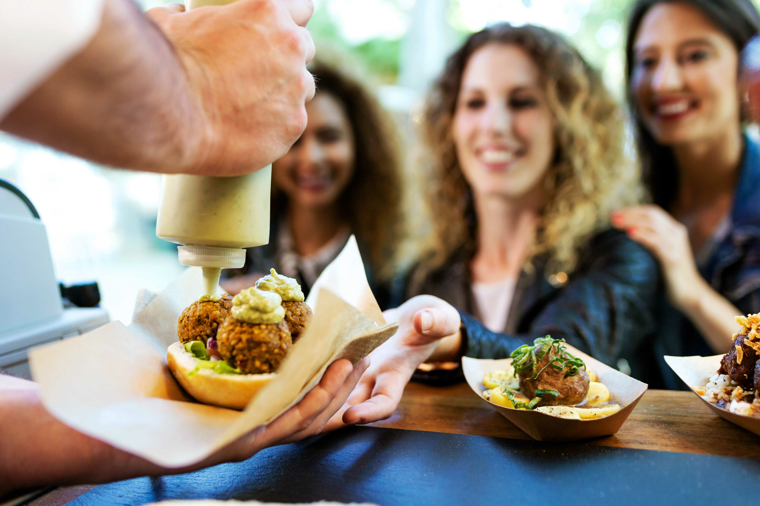 Serving food at a local food market to three happy customers.
