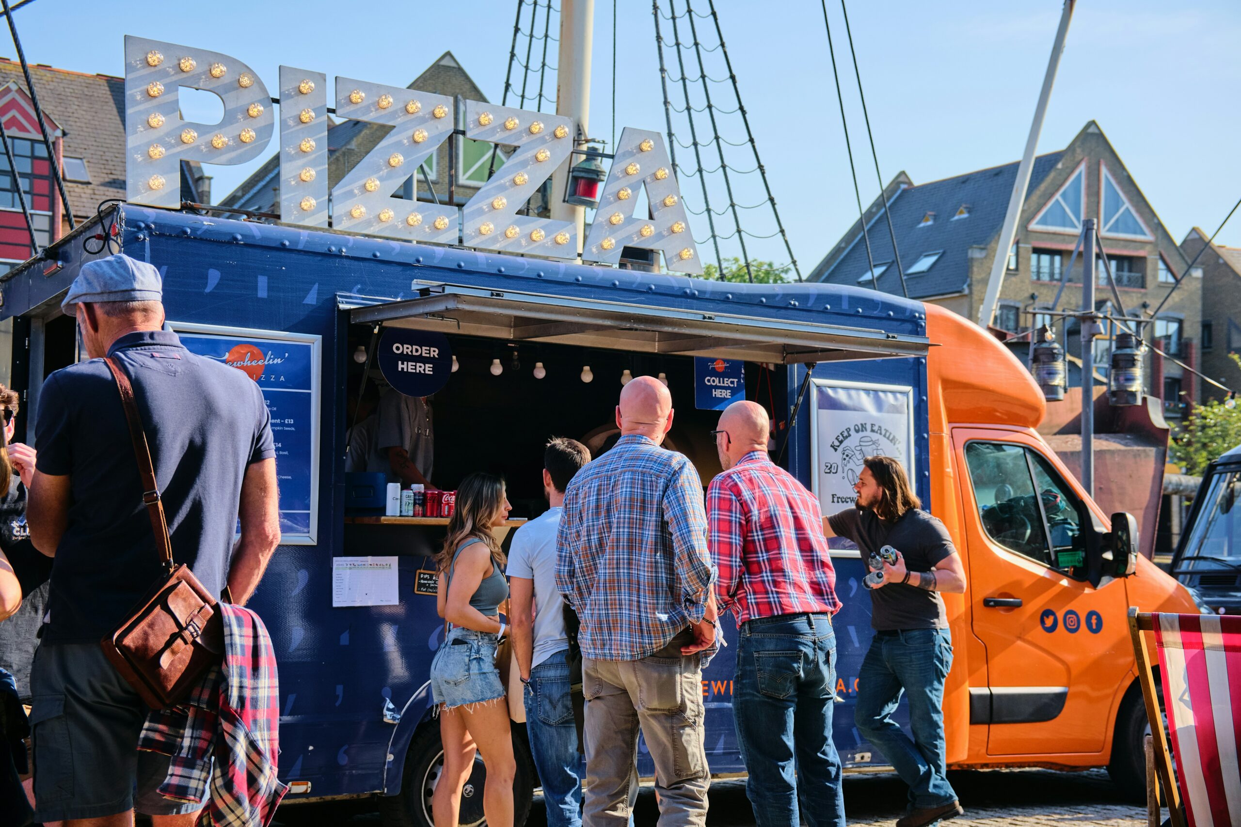 Customers stood outside a pizza food truck vendor.