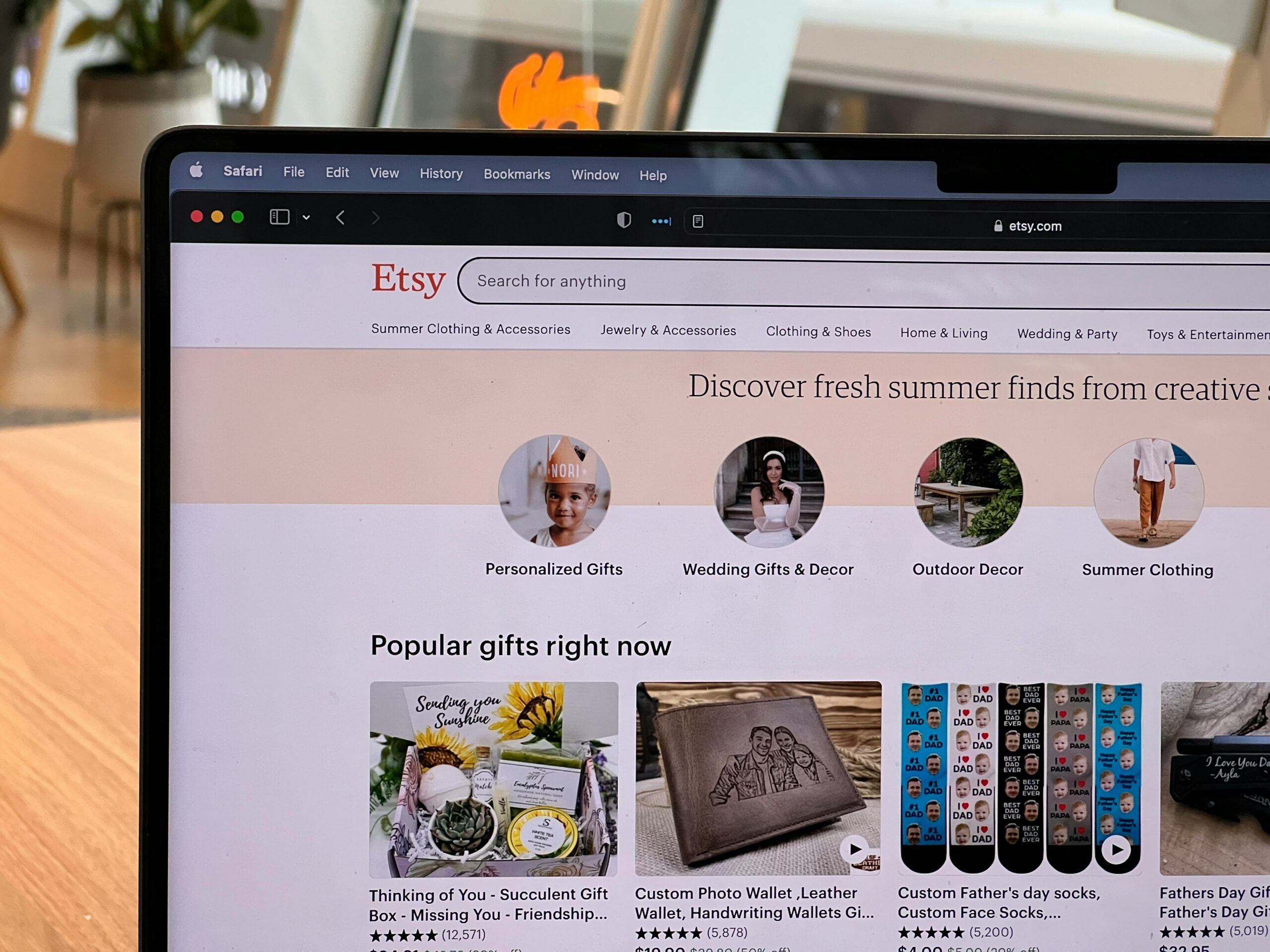 The Etsy homepage is shown on a laptop screen, displaying various handmade and vintage items.